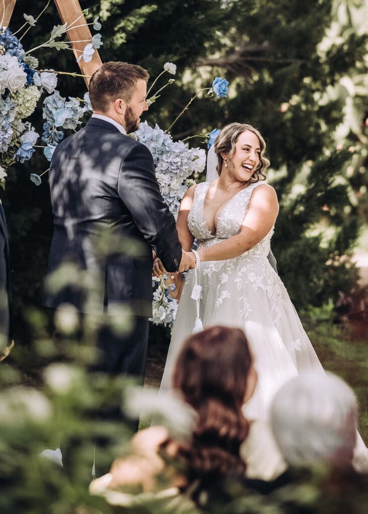 Bride and groom holding hands during outdoor wedding ceremony at Vanden Estate Mildura, photographed by Miss Moody Photography