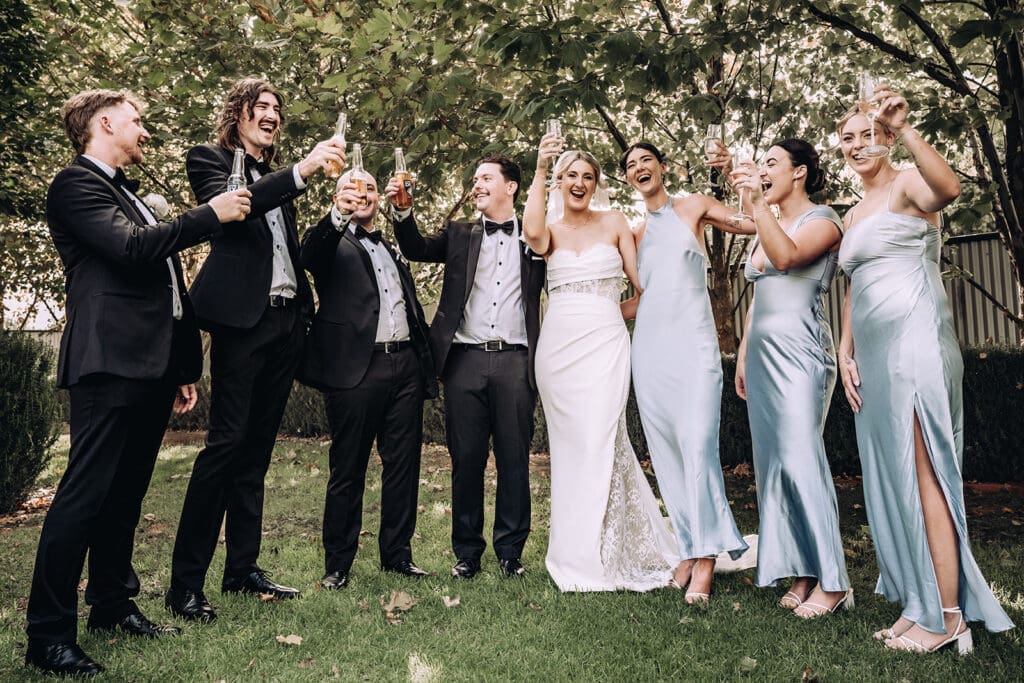 Bride and groom with their bridal party, sharing a drink at Willow and Ivie wedding venue Mildura, photographed by Miss Moody Photography 