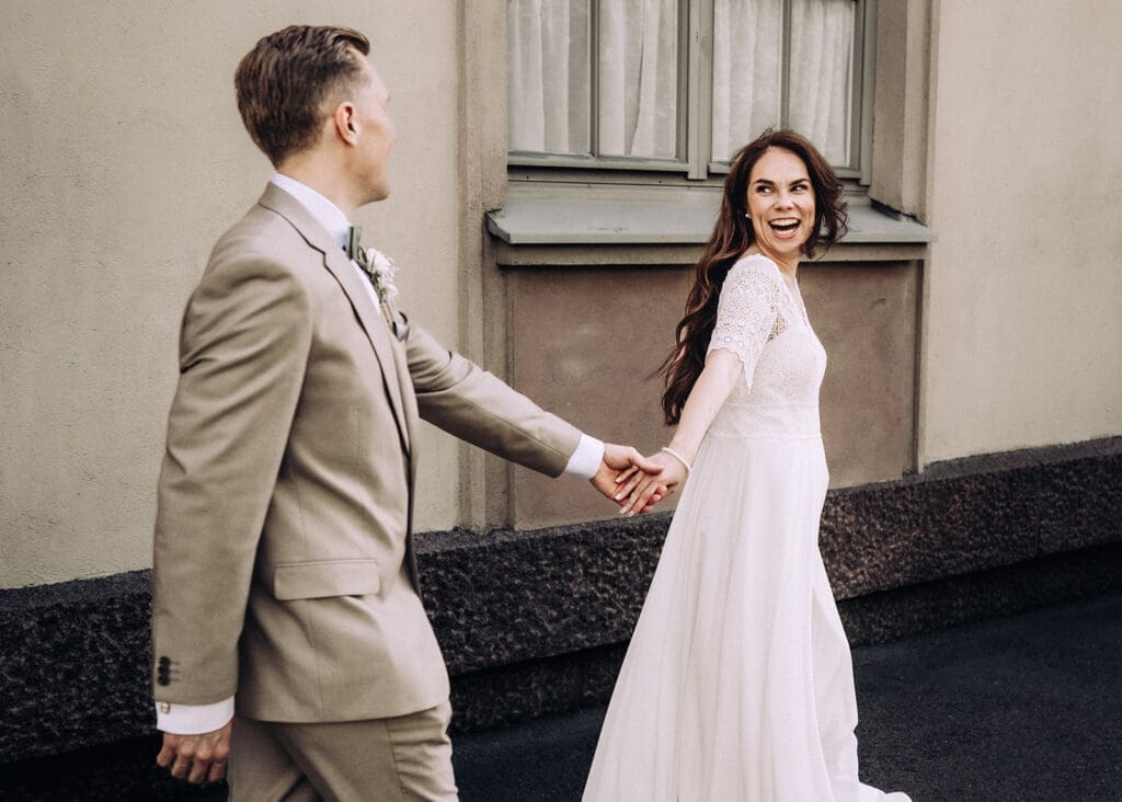 Bride and groom walking hand in hand laughing in Helsinki city centre, outdoor wedding portraits, Miss Moody Photography — Morsian ja sulhanen kävelevät käsi kädessä nauraen Helsingin keskustassa, hääkuvaus ulkona, Miss Moody Photography