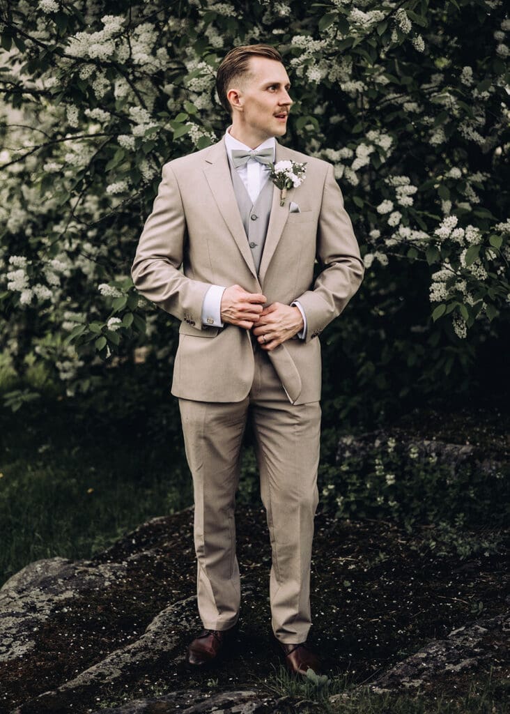 Groom in beige three piece suit standing in front of flowering trees Helsinki wedding portrait, Miss Moody Photography — Sulhanen beigessä kolmiosaisessa puvussa kukkivien puiden edessä Helsingissä häämuotokuva, Miss Moody Photography