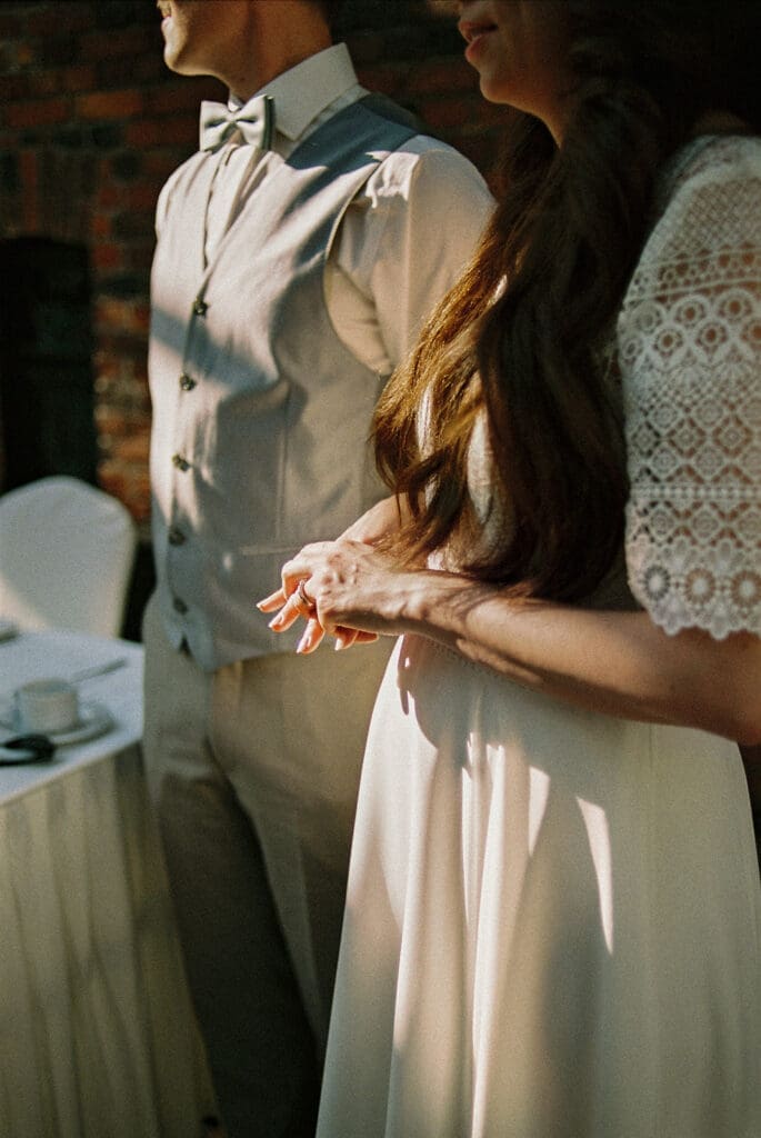 Bride and groom hands detail shot during wedding reception Ravintola Sipuli Helsinki, film photography, Miss Moody Photography — Morsiamen ja sulhasen käsien yksityiskohta häävastaanoton aikana Ravintola Sipulissa Helsingissä, filmivalokuvaus, Miss Moody Photography