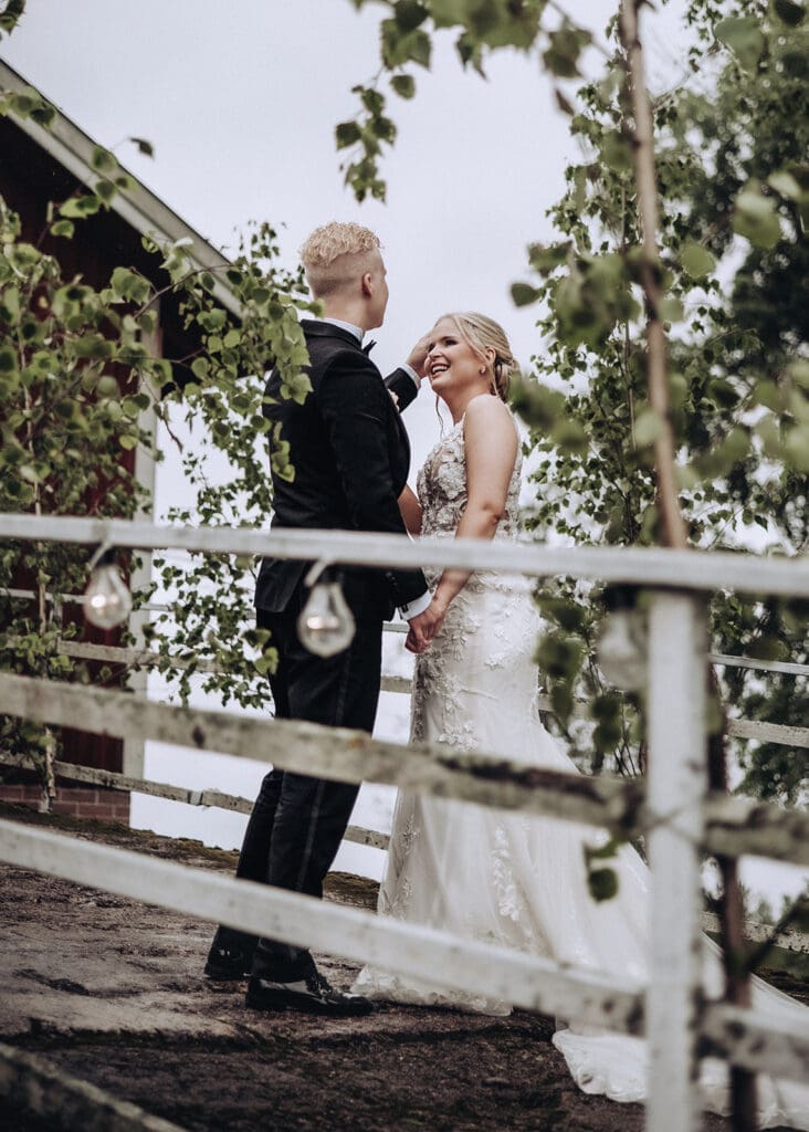 Bride and groom laughing together framed by birch trees at Finnish summer cottage wedding portrait Kymenlaakso Finland, moody documentary wedding photography by Miss Moody Photography | Morsian ja sulhanen nauravat koivujen keskellä kesämökin häämuotokuvissa Kymenlaaksossa, tunnelmallinen hääkuvaus Miss Moody Photography