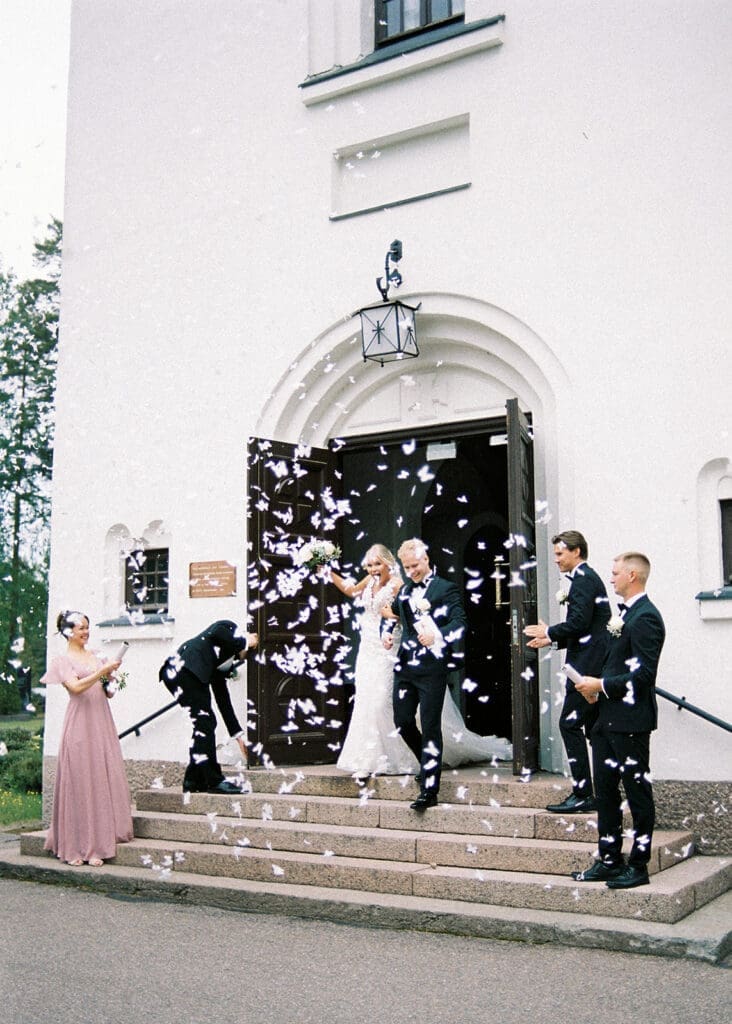 Bride and groom confetti exit at Valkeala kirkko church doors Finland, documentary wedding photography Miss Moody Photography Kymenlaakso | Morsian ja sulhanen konfetti kirkosta poistuessa Valkealassa, hääkuvaaja Kymenlaakso Miss Moody Photography