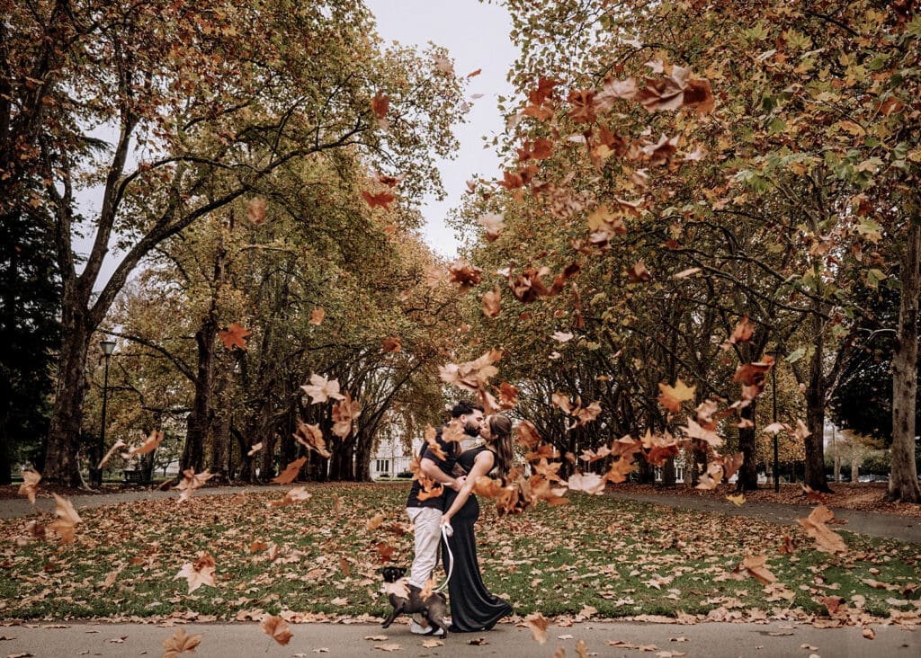 Couple kissing under autumn leaves in Carlton Gardens Melbourne engagement session
